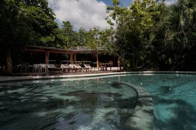 a swimming pool with chairs and a pavilion at Cala Luna Boutique Hotel & Villas in Tamarindo