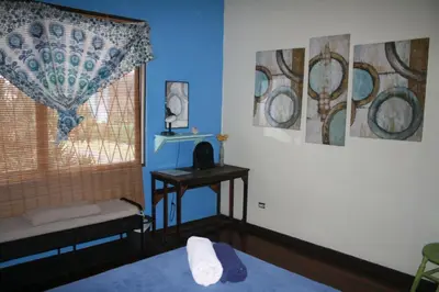 a room with a bed and a window and a table at In the Wind Hostel and Guesthouse in San José