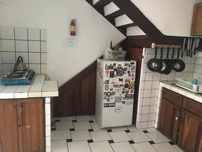 a kitchen with a refrigerator with magnets on it at In the Wind Hostel and Guesthouse in San José