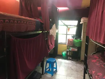 a room with two bunk beds and a blue stool at In the Wind Hostel and Guesthouse in San José