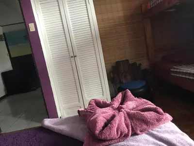 a pink towel sitting on top of a bed at In the Wind Hostel and Guesthouse in San José
