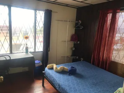 a bedroom with a bed with a stuffed animal on it at In the Wind Hostel and Guesthouse in San José