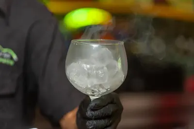 a hand holding a wine glass with ice in it at Villas Alturas in Dominical