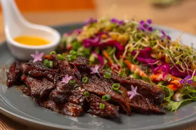 a plate of food with meat and a salad at Villas Alturas in Dominical