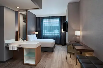 a hotel room with a bed and a sink and a desk at AC Hotel by Marriott San Jose Escazu in San José