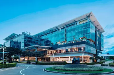 a large glass building with a statue in front of it at AC Hotel by Marriott San Jose Escazu in San José