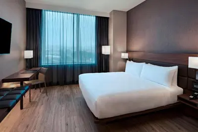 a hotel room with a large bed and a desk at AC Hotel by Marriott San Jose Escazu in San José