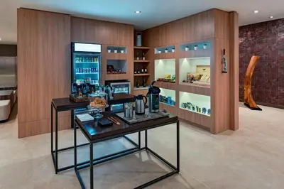 a room with two tables and a counter with drinks at AC Hotel by Marriott San Jose Escazu in San José