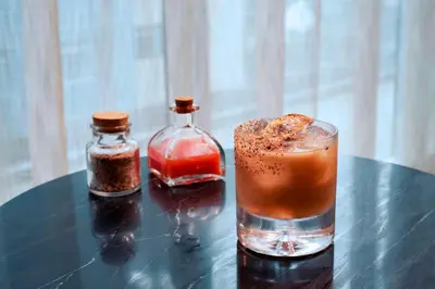a drink and a bottle of spices on a table at AC Hotel by Marriott San Jose Escazu in San José