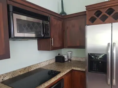 a kitchen with a stainless steel refrigerator and a microwave at Casa Malia Guapinol #8 in Tamarindo