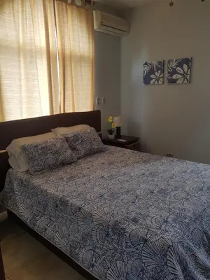a bedroom with a bed with a blue comforter and a window at Casa Malia Guapinol #8 in Tamarindo