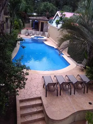 a swimming pool with chairs and a table next to it at Casa Malia Guapinol #8 in Tamarindo