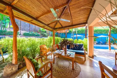 a patio with a table and chairs and a pool at Hotel Arco Iris in Tamarindo