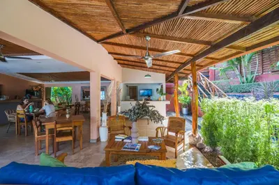 a living room with a blue couch and wooden ceilings at Hotel Arco Iris in Tamarindo