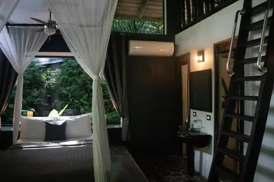 a room with a bed with a window and a ladder at Canaima Chill House in Santa Teresa Beach