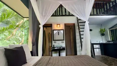 a bedroom with a bed with a staircase and a mirror at Canaima Chill House in Santa Teresa Beach