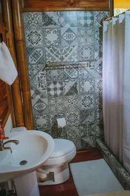 a bathroom with a white sink and a toilet at Bambura Hermosa villas in Uvita