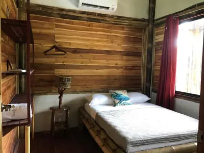 a room with a bed in a wooden wall at Bambura Hermosa villas in Uvita