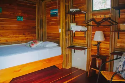 a bedroom with a bed in a wooden cabin at Bambura Hermosa villas in Uvita