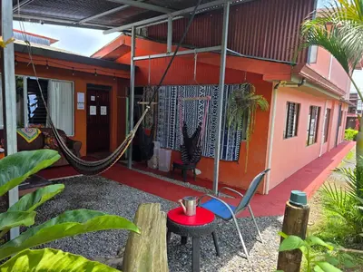 a porch with a hammock and a house at Alojamientos N&S in Fortuna