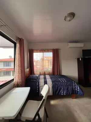 a bedroom with a bed and a desk and a window at Alojamientos N&S in Fortuna