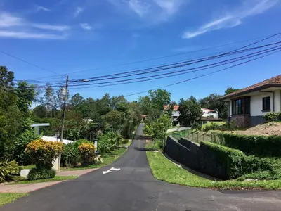 an empty street in a residential neighborhood with houses at Casa Nadette in Guácima