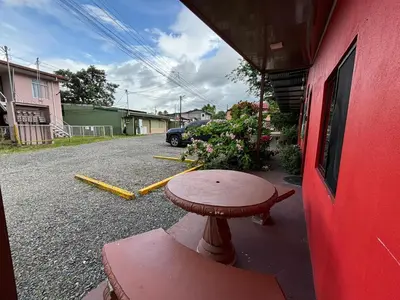 a small table sitting outside of a red building at Pura Vida Aparment - Downtown La Fortuna in Fortuna
