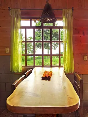 a wooden table in a room with a large window at Rancho Amalia in Naranjo