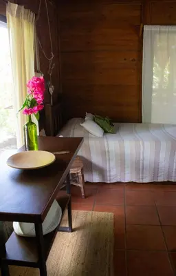 a room with a bed and a table with flowers on it at The House of Hummingbird, Costa Rica in Atenas
