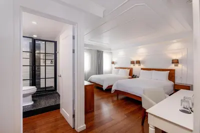 a hotel room with two beds and a bathroom at Hotel Presidente in San José