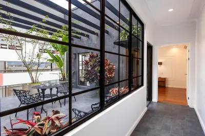 a room with large windows with a table and plants at Hotel Presidente in San José