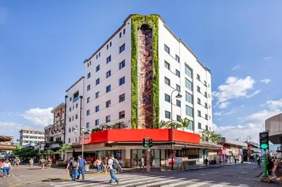 a tall building on a city street with people crossing the street at Hotel Presidente in San José