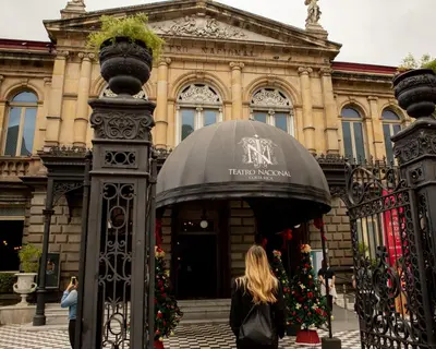 a woman walking past the entrance to a christmas museum at Hotel Presidente in San José