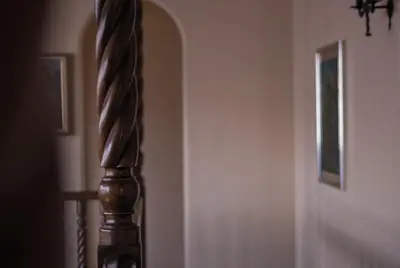 a stairway with a wooden rail next to a door at Hotel Casa Colon in San José