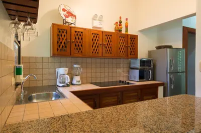 a kitchen with a sink and a refrigerator at Club del Mar Oceanfront in Jacó