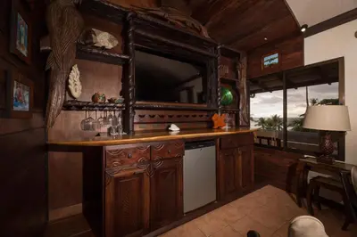a kitchen with wooden cabinets and a white dishwasher at Club del Mar Oceanfront in Jacó