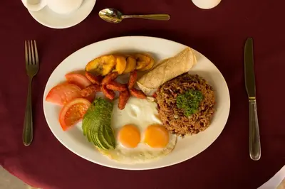a plate of breakfast food with eggs rice and vegetables at Club del Mar Oceanfront in Jacó