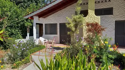 a house with a garden with flowers in front of it at Hotel Las Brisas del Pacifico in Sámara
