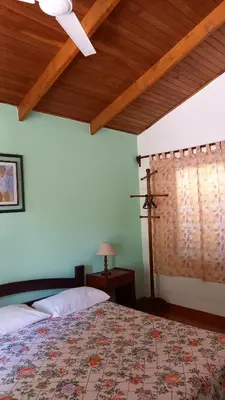 a bedroom with a bed with a ceiling fan at Hotel Las Brisas del Pacifico in Sámara