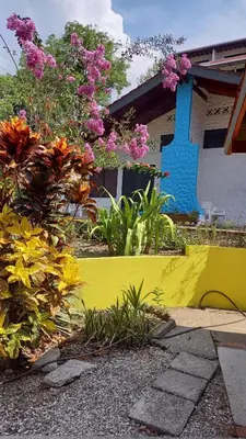 a yellow wall in front of a house with flowers at Hotel Las Brisas del Pacifico in Sámara