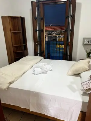 a bedroom with a large white bed with a window at Boutique Hotel Calle 20 in San José