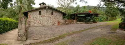 a small stone building on a dirt road at Malekus Mountain Lodge in Aguas Claras