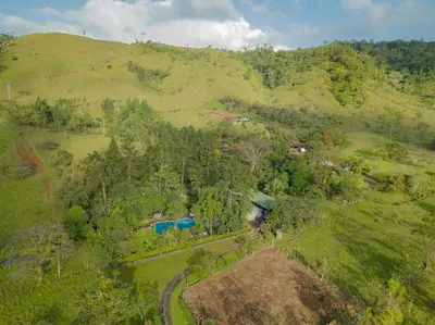 an aerial view of a hill with a house on it at Malekus Mountain Lodge in Aguas Claras