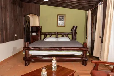 a bedroom with a bed in a room with a table at Malekus Mountain Lodge in Aguas Claras