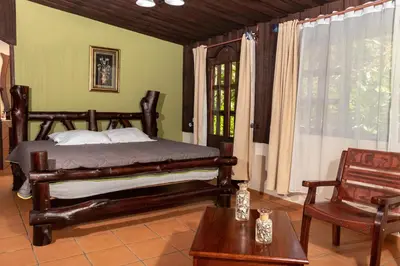 a bedroom with a bed and a table and a window at Malekus Mountain Lodge in Aguas Claras