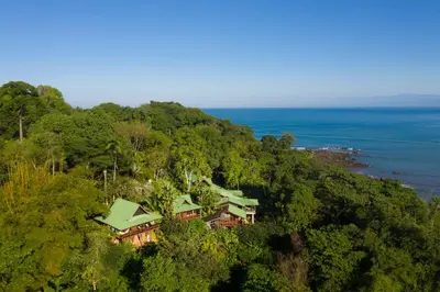 a house on top of a hill next to the ocean at Aguila de Osa Rainforest Lodge in Drake