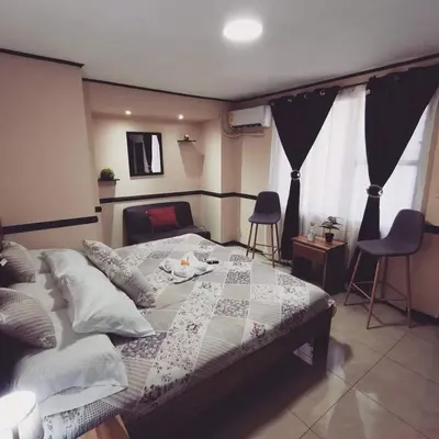a bedroom with a bed with a quilt on it at Toucan Hostel in Alajuela City