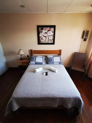 a bedroom with a bed with two towels on it at Toucan Hostel in Alajuela City