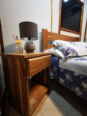 a bedroom with a bed and a table with a lamp at Toucan Hostel in Alajuela City