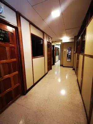an empty hallway in a building with a television on the wall at Toucan Hostel in Alajuela City
